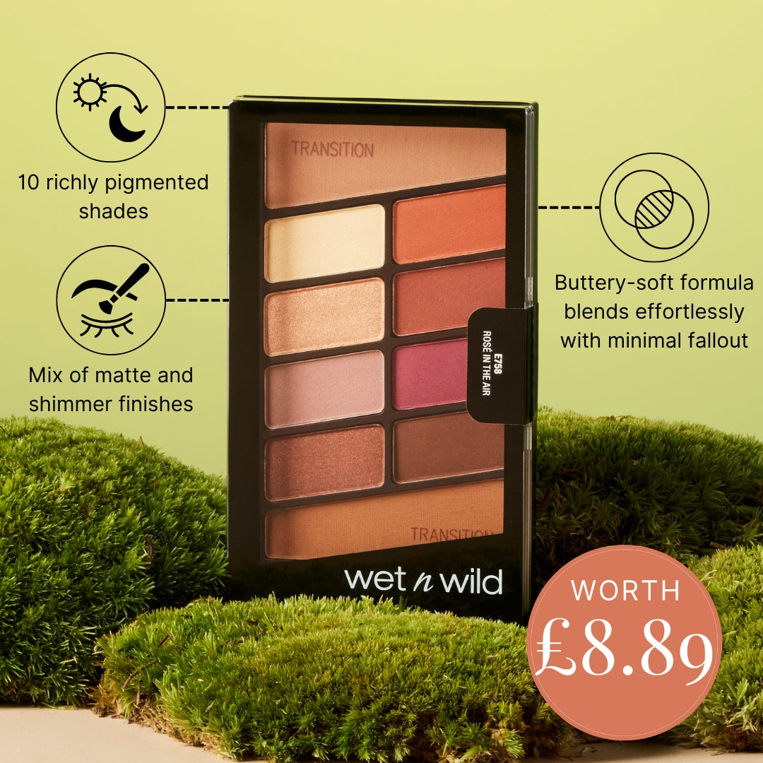 Wet n Wild Transition eyeshadow palette displayed on a green mossy background with promotional text and a price badge. The palette contains 10 richly pigmented shades in warm tones including beige, brown, pink, and orange.