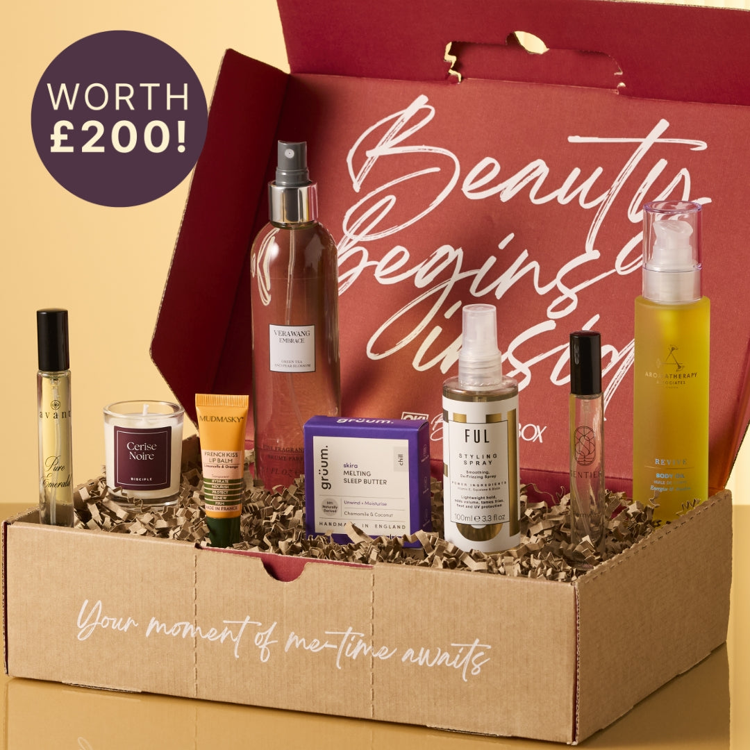 Gift set with beauty products in a box, featuring a red bag with 'Beauty Begins' text.